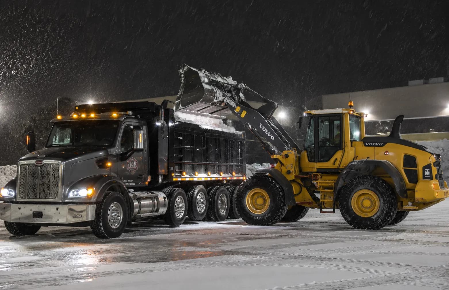 Wheel loader loading snow into a dump truck for off-site hauling in Fond du Lac, Wisconsin
