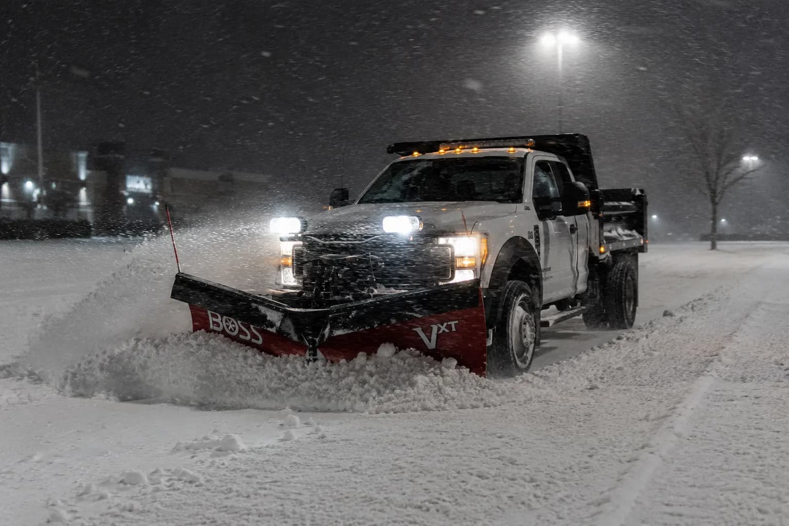 Heavy-duty plow truck clearing a commercial drive lane at night in Fond du Lac, Wisconsin